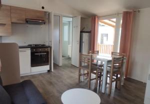 eine Küche und ein Esszimmer mit einem Tisch und Stühlen in der Unterkunft Les Dunes de Contis in Saint-Julien-en-Born