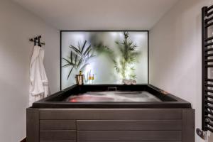 a bath tub in a bathroom with a painting of plants at The Newel Acropolis in Athens