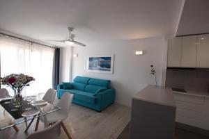 un soggiorno con divano blu e tavolo di La Playa Blanca7, El Palmeral, BEACH, SEA VIEW, POOL, WIFI a Torrevieja