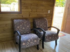 deux chaises assises l'une à côté de l'autre dans une pièce dans l'établissement Cabana Bacana, à Praia Grande