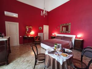 a red bedroom with a bed and a table and chairs at Chez Moi Charme B&B in Lecce