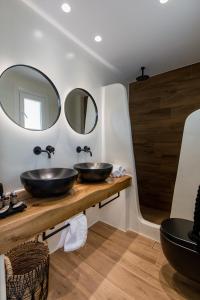 dois lavatórios numa casa de banho com dois espelhos em Rodillo Apartments em Plaka