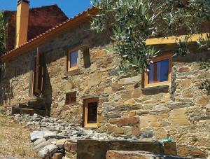 a stone house with windows on the side of it at Casas da Cabrieira in Proença-a-Nova