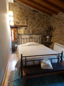 1 dormitorio con 1 cama en una pared de piedra en Casas da Cabrieira, en Proença-a-Nova