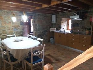 a kitchen and dining room with a table and chairs at Casas da Cabrieira in Proença-a-Nova