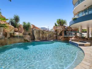a pool in a resort with a water slide at Top Floor Beachside Apartment in the Heart of Mooloolaba in Mooloolaba