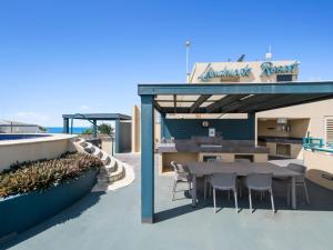 a restaurant with a table and chairs on a patio at Top Floor Beachside Apartment in the Heart of Mooloolaba in Mooloolaba