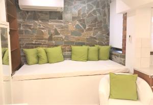 a white bench with green pillows in a room at Amaryllis House in Platamonas