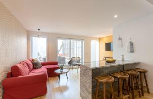 ein Wohnzimmer mit einem roten Sofa und einer Küche in der Unterkunft Lemon Tree Family Apartment in Porto