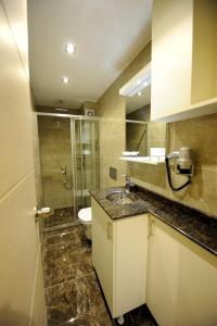a bathroom with a sink, toilet, and shower at Rooms Inn Taxim in Istanbul