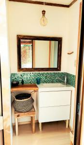 een badkamer met een wastafel en een spiegel bij AKUA inn in Awaji