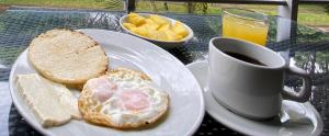 a plate with an egg and bread and a cup of coffee at Hotel Campestre Paraiso Cafetero in Montenegro