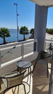 a balcony with two chairs and a table and a view of the ocean at Amanecer Petit in Miramar