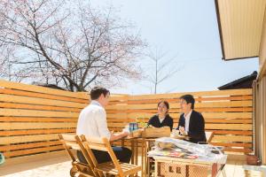eine Gruppe von drei Personen, die an einem Tisch sitzen in der Unterkunft tathata in Karuizawa