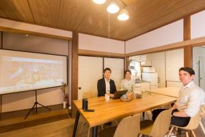 輕井澤的住宿－tathata，一群人坐在一个房间里桌子旁