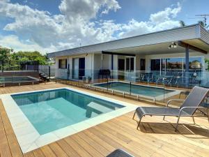 a house with a swimming pool on a deck at 4 bedroom home on canal in Mooloolaba