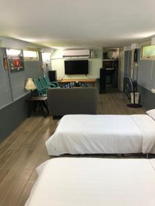 ein Schlafzimmer mit 2 Betten und ein Wohnzimmer in der Unterkunft Oliver Tree B&B in Fenglin