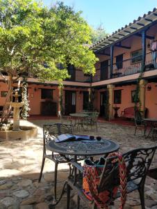 une terrasse avec une table et des chaises devant un bâtiment dans l'établissement Hotel Plazuela de San Agustín, à Villa de Leyva