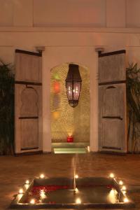 Habitación con lámpara de araña y mesa con luces. en Riad O2, en Marrakech