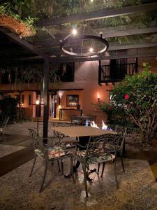 a table and chairs in a patio at night at Hotel Plazuela de San Agustín - PSA Hotel in Villa de Leyva