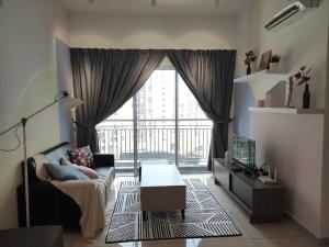 a living room with a couch and a large window at Ezhome Mesahill in Nilai