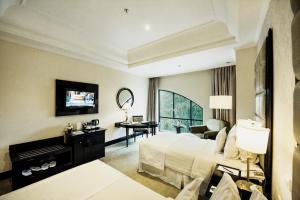 a large hotel room with a bed and a desk at The Papandayan in Bandung