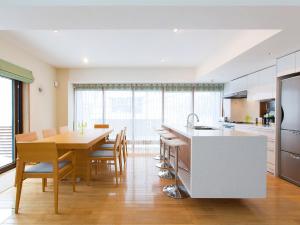 uma cozinha com uma mesa de madeira e uma sala de jantar em Kita Kitsune Chalet em Niseko
