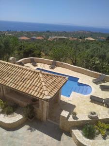 een zwembad met een tegeldak en een patio bij Villa Antares in Riglia