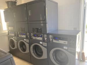 eine Gruppe von drei Waschmaschinen in einer Küche in der Unterkunft Soustons plage Maison terrasse 2 pers et 1 enfant Les villas du lac Tennis mini golf in Soustons