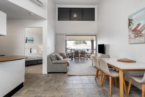 een keuken en een woonkamer met een tafel en stoelen bij Lennox Holiday Apartments in Lennox Head