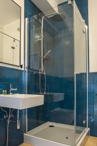 a bathroom with a glass shower and a sink at Na Skałce Apartment in Kraków
