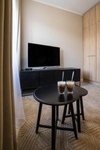uma sala de estar com uma mesa de centro e uma televisão em Na Skałce Apartment em Cracóvia