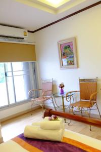 ein Wohnzimmer mit einem Tisch und Stühlen in der Unterkunft WeRest Hotel in Khon Kaen