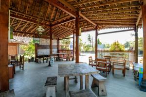 a pavilion with wooden tables and chairs and a table at Balkondes Duta Menoreh in Magelang