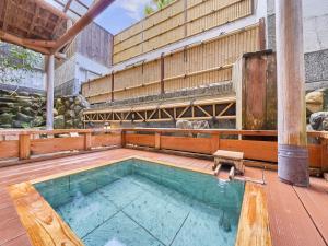 einen Pool auf einer Holzterrasse mit einem Gebäude in der Unterkunft Yukai Resort Terunoyu in Maniwa