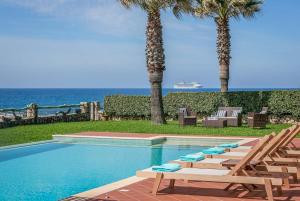 a swimming pool with lounge chairs and the ocean at Sunset in Minia