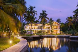 un resort con piscina e palme di notte di ama Stays & Trails Sherlys Ente Kumbalanghi, Kochi a Tekkumuri