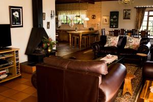 - un salon avec un canapé en cuir et une table dans l'établissement Mountain Haven Villa, à Wolseley
