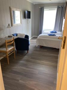 a hotel room with a bed and a chair at Førde Pensjonat in Førde