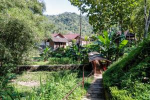 un pequeño puente sobre un río en un pueblo en Balkondes Kenalan en Magelang