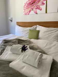 Una cama blanca con toallas y flores. en Hotel Weisses Rössli, en Göschenen