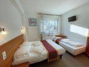 Postel nebo postele na pokoji v ubytování Hotel Le Ronchamp