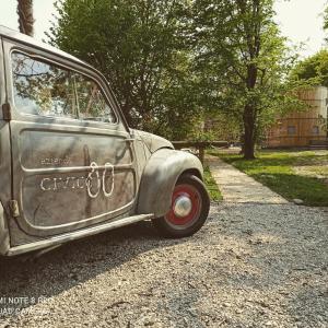 SuseganaにあるAffittacamere Civico 80の砂利道に停められた古い灰色の車