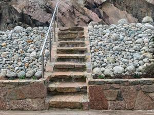 un escalier en pierre à côté d'une pile de rochers dans l'établissement 8 person holiday home in Urangsv g, à Ervik