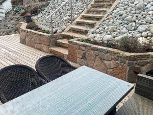 a table and chairs on a deck with rocks at 8 person holiday home in Urangsv g in Ervik