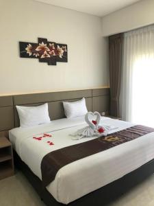a bedroom with a large bed with flowers on it at Grand Samota Hotel in Sumbawa Besar