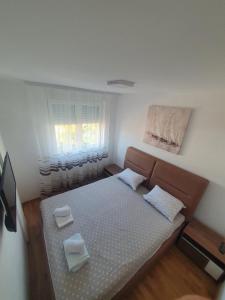 a small bedroom with a bed and a window at Nina Apartman in Soko Banja