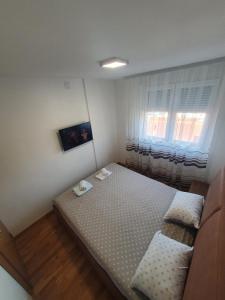 a small bedroom with a bed and a window at Nina Apartman in Soko Banja