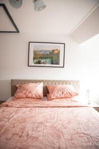 a bedroom with a bed with a pink comforter at Bed and Wine Nonsolovino in Reeuwijk