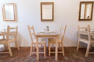 une table et des chaises dans une pièce avec miroirs dans l'établissement Casa Memi, à Marzamemi